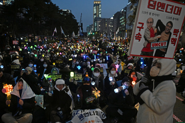 윤석열 대통령에 대한 국회의 2차 탄핵소추안 표결을 하루 앞둔 13일 오후 서울 여의도 국회 앞에서 열린 '윤석열 즉각 탄핵 촉구 촛불문화제'에서 참가자들이 응원봉과 손피켓을 들고 있다. 조태형 기자