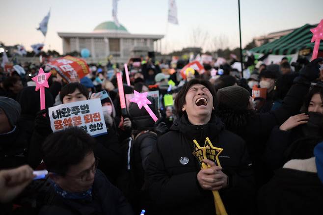 윤석열 대통령 탄핵소추안이 가결된 14일 서울 영등포구 국회 앞에서 열린 ‘내란수괴 윤석열 즉각탄핵’ 범국민 촛불대행진에서 시민들이 환호하고 있다. (사진=뉴시스).