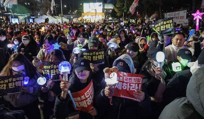 비상계엄 후폭풍이 계속되고 있는 지난 11일 오후 서울 여의도 국회 앞에서 열린 윤석열 대통령 탄핵 촉구 촛불 집회 참가 시민들이 촛불과 응원봉을 들고 국민의힘 당사를 향해 행진하고 있다. 연합뉴스