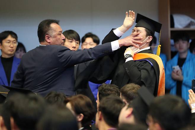 2월16일 대전 유성구 한국과학기술원(KAIST) 학위수여식 도중 졸업생 신민기씨가 “연구개발(R&D) 예산 복원하십시오”라고 소리치는 순간 경호원이 입을 막으며 제지하고 있다. 대전충남사진공동취재단