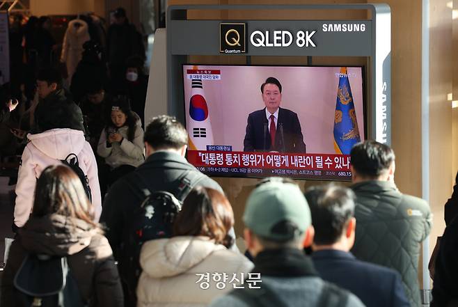 지난 12월 12일 서울 용산구 서울역에서 시민들이 윤석열 대통령의 긴급 성명 발표를 지켜보고 있다.  / 권도현 기자