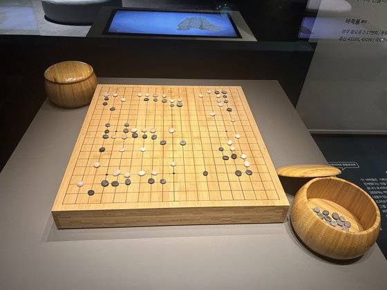국립경주박물관의 특별전 '소소하고 소중한'(2025년 3월 9일까지)에서 선보이고 있는 신라인들의 바둑돌. 경주시 황오동 신라시대 건물터에서 출토됐다. 지름 1.3~1.6㎝1크기의 납작한 돌로 백돌 43개와 흑돌 55개가 나왔다. 전시장에선 이해를 돕기 위해 현대 바둑판 위에 포석하듯 진열해놨다. 경주=강혜란 기자
