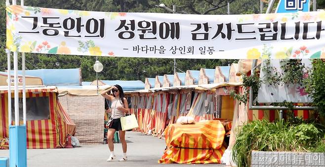 (부산=뉴스1) 윤일지 기자 = 19일 부산 해운대구 바다마을 포장마차촌 입구에 바다마을 상인회의 '그동안의 성원에 감사드린다'고 적힌 현수막이 내걸려 있다.   해운대구에 따르면 구와 포장마차촌 상인들은 지속적인 협의 끝에 자진 철거에 합의했다. 오는 24일까지 상인들이 각자 물건을 정리하면 구는 25일부터 60여 명의 인력과 포크레인, 지게차 등을 동원해 잔재물 정리에 나설 예정이다. 해당 포장마차촌이 있던 자리에는 공영주차장이 들어설 예정이다. 2024.6.19/뉴스1  Copyright (C) 뉴스1. All rights reserved. 무단 전재 및 재배포,  AI학습 이용 금지. /사진=(부산=뉴스1) 윤일지 기자