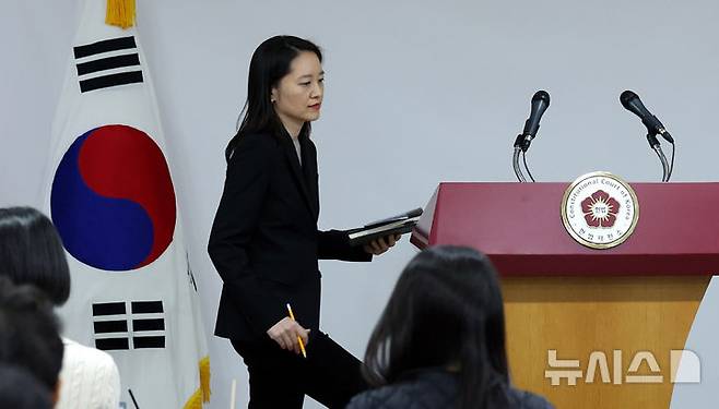 [서울=뉴시스] 추상철 기자 = 이진 헌법재판소 공보관이 16일 오후 서울 종로구 헌법재판소에서  '윤석열 대통령 탄핵심판 사건'과 관련 브리핑을 위해 단상으로 향하고 있다. 2024.12.16. scchoo@newsis.com