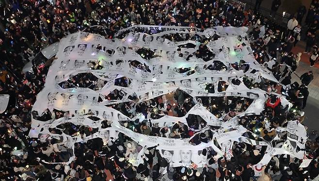 ▲ 탄핵소추안 투표 불참 의원 규탄 현수막 찢는 시민들 [연합뉴스]&nbsp;