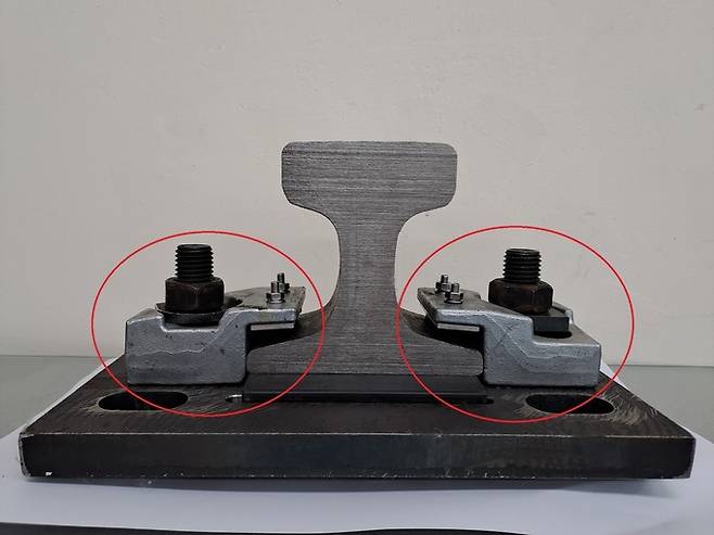 부산항 신항에 있는 부두 컨테이너 이동용 크레인 하부 레일에 들어가는 고정 장치(빨간 원). 부산의 한 중소 종합건설사가 부산항만공사의 제안으로 독자기술로 이 장치를 대체할 신제품을 만들었다. A사 제공