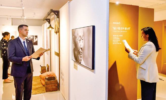 해외성도방문단으로 한국을 찾은 미국인들이 영어로 번역된 작품집을 읽으며 관람하고 있다. [하나님의 교회 제공]