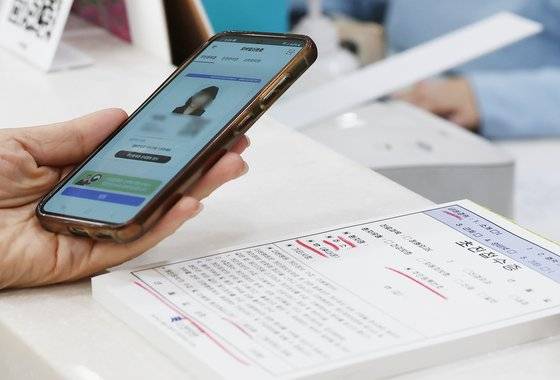 서울 동작구 한 병원에서 시민이 접수를 하며 모바일신분증을 보여주고 있다.  [뉴스1]