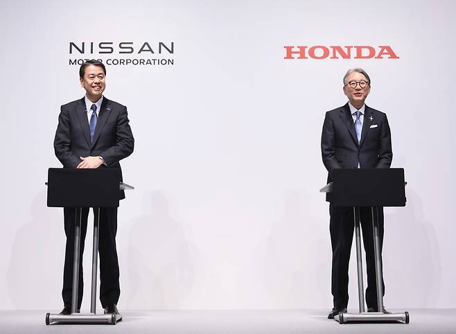 Nissan Motor CEO Makoto Uchida (left) and Honda Motor CEO Toshihiro Mibe pose for a photo during a press conference in March this year. (Honda, Nissan)