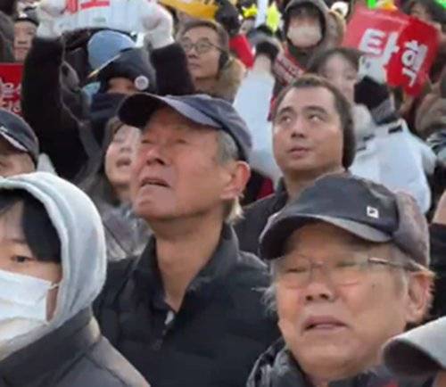 윤석열 대통령에 대한 2차 탄핵소추안이 지난 14일 국회에서 가결되자 환호하는 시민들 사이에서 눈물을 터뜨린 이승방(77) 할아버지가 영국 BBC 카메라에 포착됐다. BBC뉴스 코리아 캡처