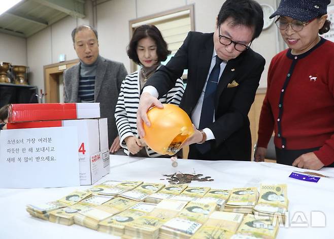 [전주=뉴시스] 김얼 기자 = 20일 전북 전주시 노송동 주민센터에서 직원들이 '얼굴 없는 천사'가 전달한 성금을 정리하고 있다. 얼굴없는천사는 성금과 함께 "소년소녀 가장 여러분 따뜻한 한 해 보내시고 새해 복 많이 받으세요."라고 적힌 편지를 함께 보내왔다. 2024.12.20. pmkeul@newsis.com