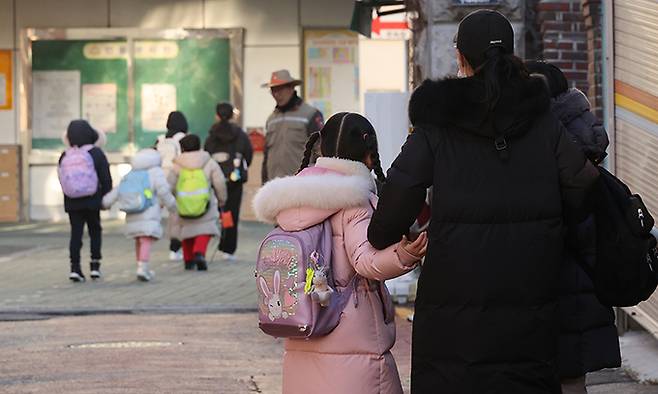 서울 한 초등학교 부근에서 학부모가 자녀들과 교문으로 향하고 있다. 연합뉴스