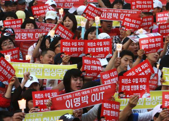 Protesters in central Seoul hold candles and placards demanding the ban on U.S. beef imports during the former Lee Myung-bak administration on June 9, 2008. [JOONGANG ILBO]