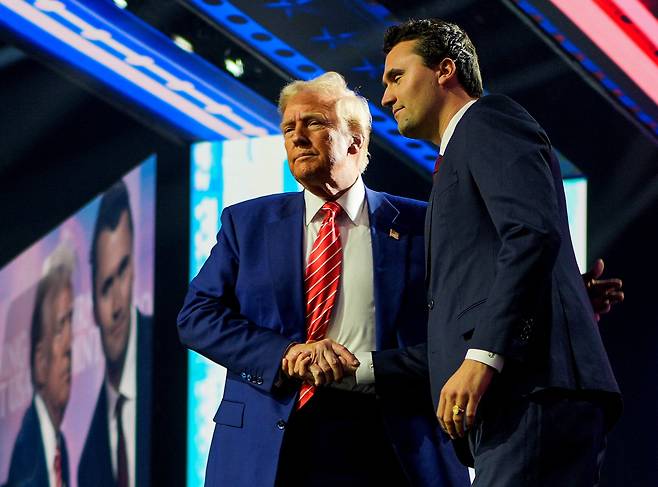 도널드 트럼프 미국 대통령 당선인이 22일(현지 시각) 청년 보수단체인 '터닝포인트 USA(Turning Point USA)’가 애리조나주 피닉스에서 개최한 '아메리카 페스트 2024(America Fest 2024)'에 참석해 터닝포인트 USA 창립자인 찰리 커크와 악수하고 있다. / 로이터