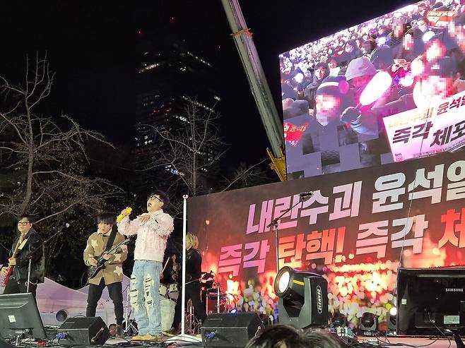 가수 이승환이 집회 무대에서 공연하고 있다. 무대 화면에는 이를 즐기는 시민들의 모습이 보인다. 송선교 인턴기자