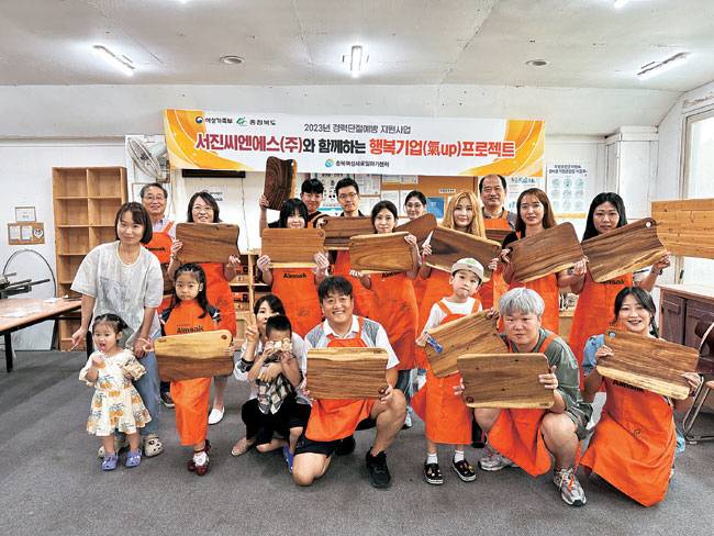 덕산네오룩스와 서진씨엔에스가 올해 고용노동부의 ‘청년친화강소기업’에 선정된 가운데 서진씨엔에스 직원들이 목공체험을 통해 만든 작품을 선보이는 모습. 각 사 제공