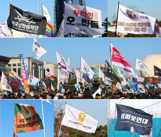 윤석열 대통령에 대한 두 번째 탄핵소추안 국회 표결일인 지난 14일 서울 여의도 국회 앞에서 '윤석열 즉각 퇴진·사회대개혁 비상행동' 주최로 열린 촛불집회에 '전국낭만해적단, 무적의 오빠들, 그냥 고양이 자랑하려고 깃발만든사람, 전국아늑한쓰레기통민연합, 생파못연대' 등등 이색 단체의 이색적인 깃발들이 펄럭이고 있다. 연합뉴스