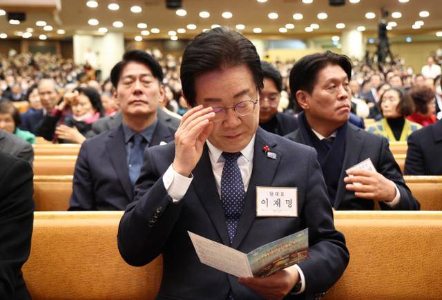 이재명 더불어민주당 대표가 25일 서울 여의도순복음교회에서 열린 성탄예배에 참석해 안내문을 보고 있다. 연합뉴스