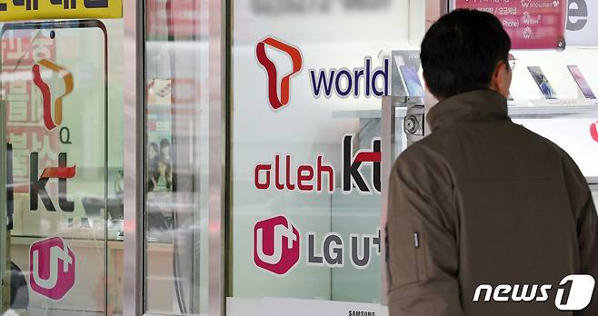 22일 오후 서울의 한 휴대폰 매장 앞으로 시민이 지나가고 있다.. 2024.2.22/뉴스1 ⓒ News1 장수영 기자