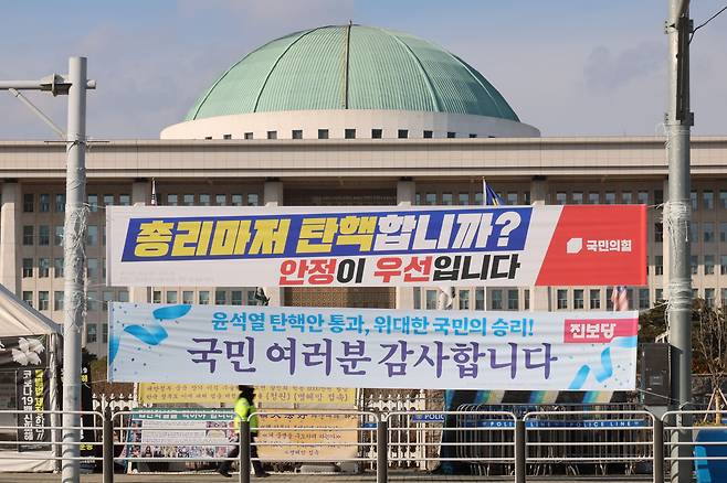 [서울=뉴시스] 권창회 기자 = 25일 서울 여의도 국회 앞에 각 당이 내건 현수막이 걸려있다. 더불어민주당은 지난 24일 한덕수 대통령 권한대행의 탄핵소추안을 당론 채택했으나 국회 추천 몫 헌법재판관 3명의 임명 여부를 지켜보겠다며 당초 계획을 보류했다. 2024.12.26. kch0523@newsis.com