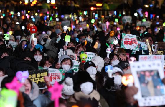 지난 24일 서울 종로구 경복궁역 앞에서 윤석열즉각퇴진-사회대개혁 비상행동 주최로 열린 메리퇴진 크리스마스 민주주의 응원봉 콘서트 - 다시 만들 세계에서 시민들이 손 피켓과 응원봉을 들고 있다. 뉴시스