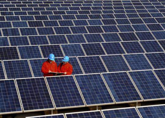 중국 동부 저장성 창싱의 한 공장 지붕에 설치된 태양광 발전소에서 근로자들이 태양광 패널을 점검하고 있다.  연합뉴스.
