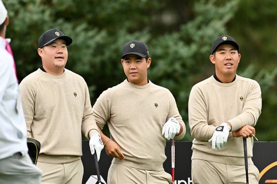 From left: Im Sung-jae, Tom Kim and An Byeong-hun of the International Team look on during a practice round prior to the Presidents Cup at The Royal Montreal Golf Club on Sept. 24 in Montreal, Quebec, Canada. [GETTY IMAGES]