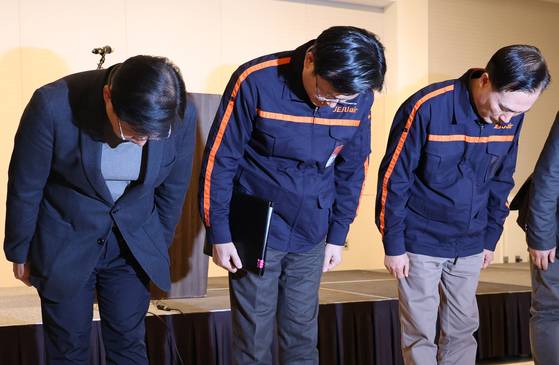 Jeju Air CEO Kim E-bae, center, bows his head during an emergency press conference held at the Mayfield Hotel in Gangseo District, western Seoul, on Dec. 29. [YONHAP]