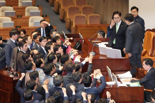 우원식 국회의장이 지난 27일 국회 본회의에서 한덕수 국무총리 탄핵소추안 가결 의결정족수에 대한 설명을 하자, 국민의힘 권성동 원내대표를 비롯한 의원들이 거세게 항의하고 있다. 연합뉴스