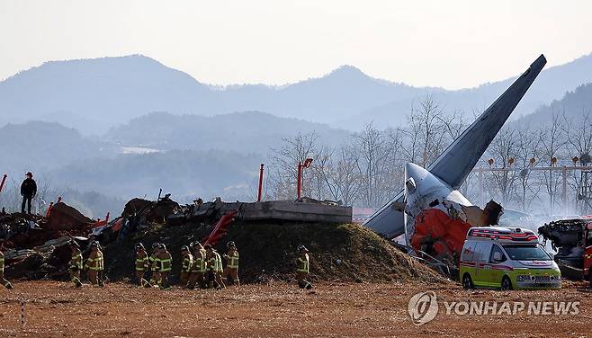 무안공항 여객기 사고 (무안=연합뉴스) 조남수 기자 = 29일 오전 전남 무안국제공항에서 착륙 중이던 항공기가 활주로를 이탈해 울타리 외벽을 충돌했다. 사진은 사고 현장에서 소방 당국이 인명 구조를 하는 모습. 2024.12.29 iso64@yna.co.kr