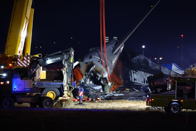 29일 전남 무안군 무안국제공항에서 충돌 폭발 사고로 파손된 제주항공 여객기 기체의 후미 부분이 크레인에 매달려 있다. 이날 참사로 항공기 탑승자 181명 중 179명이 숨졌다. 무안=연합뉴스