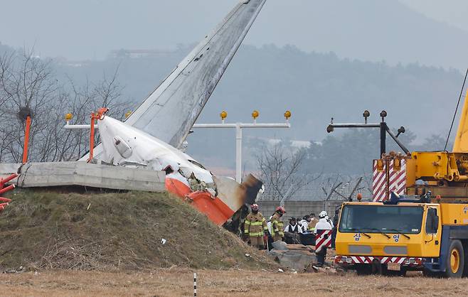 Authorities conduct a search on Monday at the site of the Jeju Air crash at Muan International Airport in South Jeolla Province. (Yonhap)