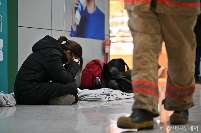 [무안=뉴시스] 이영주 기자 = 제주항공 소속 여객기 착륙 도중 충돌 사고 이튿날인 30일 오전 전남 무안군 무안국제공항 2층 대합실에서 한 유족이 주저앉아 머리를 붙잡고 있다. 2024.12.30. leeyj2578@newsis.com /사진=