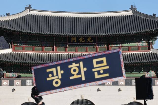 한글단체 회원이 직접 제작한 한글 현판을 들고 있는 모습. 연합뉴스