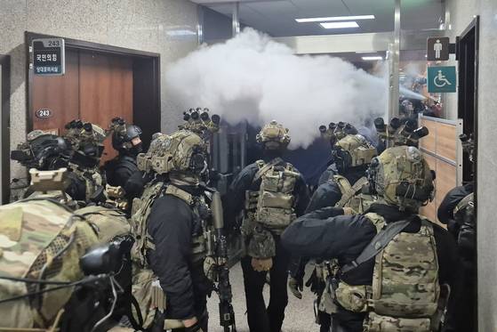 Parliament lawmakers hose water with a fire extinguisher on the special forces deployed to the National Assembly in western Seoul to stop them from voting and rebuff President Yoon Suk Yeol's emergency martial law declaration made a few hours earlier on Dec. 3. [YONHAP]