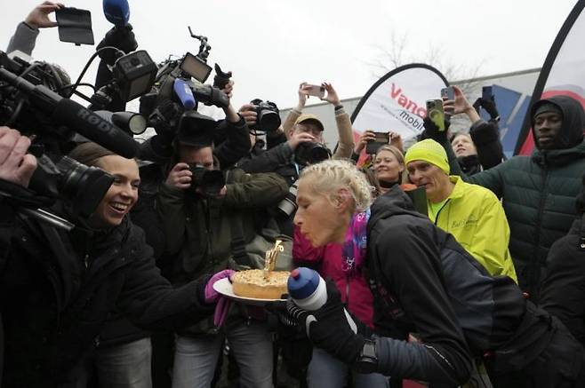 지난해 12월 31일 힐다 도손이 366번째 마라톤 풀코스 완주 결승점을 통과한 뒤 축하 케이크의 촛불을 불고 있다. AP연합뉴스