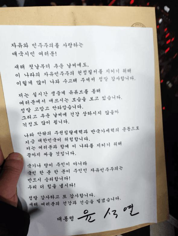 1일 윤석열 대통령이 자필 서명한 입장문을 통해 “나라 안팎의 주권 침탈 세력과 반국가 세력의 준동으로 대한민국이 위험하다”며 “저는 여러분과 함께 이 나라를 지키기 위해 끝까지 싸울 것”이라고 했다. 윤 대통령 측 석동현 변호사는 서울 용산구 한남동 관저 앞에서 열린 집회의 진행자가 이 새해 인사 겸 지지 감사의 글을 전달받고 사진을 찍어 참석자들에게 전파했다고 밝혔다. 김용현 전 국방부 장관 측 제공