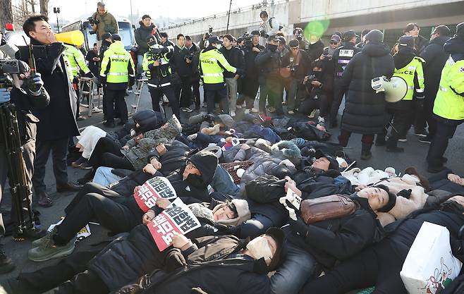 고위공직자범죄수사처가 내란 수괴(우두머리)·직권남용 혐의를 받는 윤석열 대통령의 체포영장을 유효기간인 6일 이전에 집행하겠다고 밝힌 가운데 2일 서울 용산구 한남동 대통령 관저 정문 앞 도로에 지지자들이 손팻말을 들고 누워있다. /연합뉴스