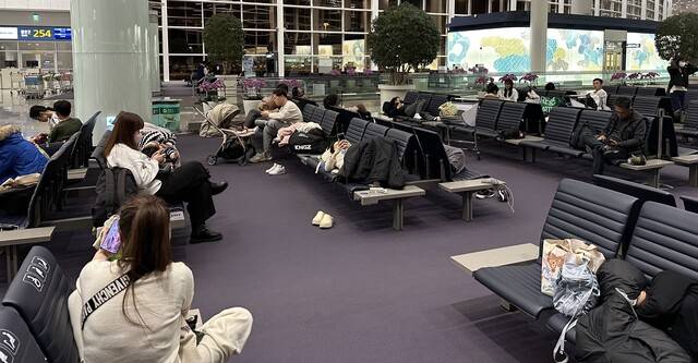 1일 밤 인천국제공항에서 대한항공을 타고 마카오로 가려던 승객들이 비행기의 기체 이상으로 운항이 중단된 뒤 내려와 게이트 앞에서 대체 비행기를 기다리고 있다. 승객 제공.