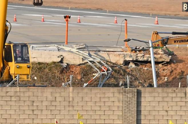 무안국제공항 활주로 담장 너머로 사고 당시 여객기가 충돌한 로컬라이저의 콘크리트 구조물이 쓰러져 있는 모습. (사진=뉴시스)