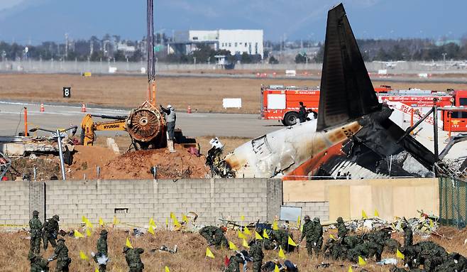 제주항공 여객기 참사 엿새째인 3일 오후 전남 무안국제공항 참사 현장에서 로컬라이저(방위각시설) 둔덕에 파묻힌 제주항공 7C2216편의 엔진이 크레인으로 인양되고 있다. /뉴스1