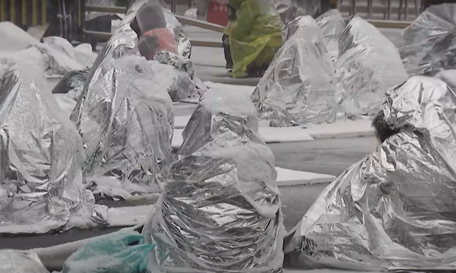 서울 전 지역에 대설주의보가 내려진 5일 오전 서울 용산구 관저 인근 ‘노동자 시민 윤석열 체포대회’ 농성장에서 은박지를 뒤집어쓴 시민들이 농성하고 있다. MBC 뉴스 갈무리