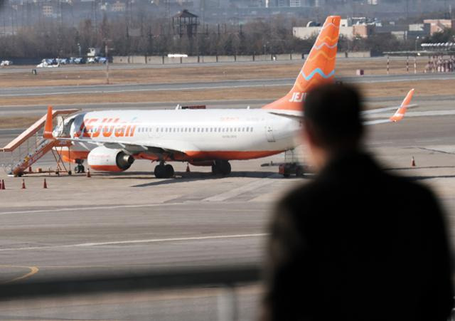 전남 무안국제공항 제주항공 여객기 참사 사흘째인 지난해 12월 31일 오후 서울 강서구 김포국제공항 국내선 청사에서 한 승객이 이륙 준비 중인 제주항공 여객기를 바라보고 있다. 뉴스1