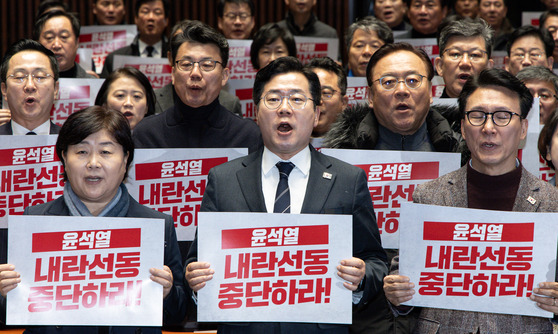 박찬대 더불어민주당 원내대표를 비롯한 의원들이 4일 오후 서울 여의도 국회에서 열린 비상의원총회에서 피켓을 들고 구호를 외치고 있다.뉴스1