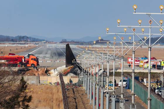 전남 무안군 무안국제공항 활주로에 전날 동체 착륙을 시도하다 충돌 후 폭발한 제주항공 여객기의 흔적과 잔해가 남아 있다. [연합뉴스]