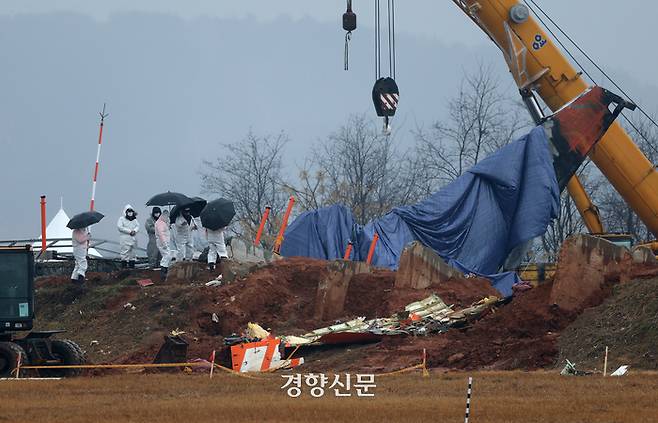 무안공항 제주항공 여객기 참사 8일째인 5일 전남 무안국제공항 사고현장에서 관계자들이 방위각시설(로컬라이저)을 살펴보고 있다.