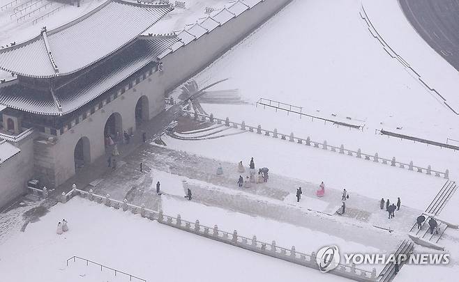 서울 등 수도권 대설특보 (서울=연합뉴스) 홍해인 기자 = 서울 등 수도권에 대설특보가 내려진 5일 서울 광화문 월대에서 관광객들이 오가는 가운데 작업자들이 눈을 치우고 있다. 2025.1.5 hihong@yna.co.kr