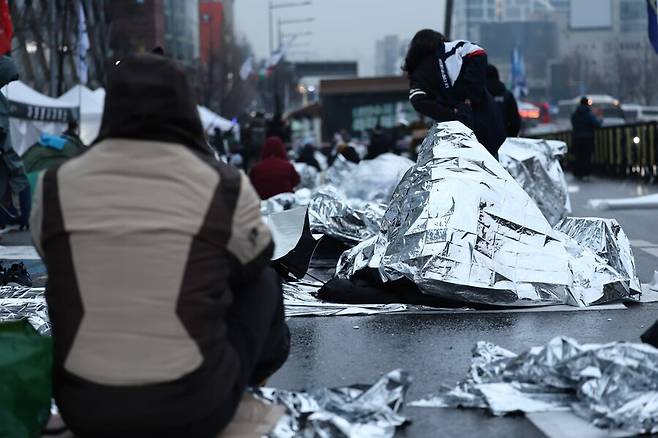 윤석열 대통령의 체포영장 유효기간 만료일인 6일 오전 서울 용산구 한남동 대통령 관저 앞 한남대로에서 은박담요를 뒤집어쓴 시민들이 투쟁을 이어가고 있다. 연합뉴스