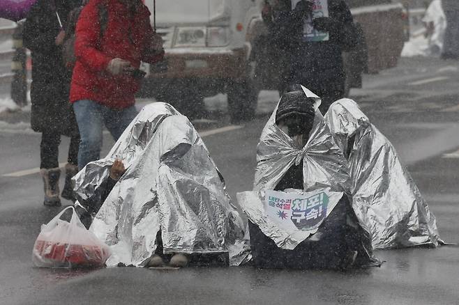 서울 전 지역에 대설주의보가 내려진 5일 오전 서울 용산구 관저 인근 ‘노동자 시민 윤석열 체포대회’ 농성장에서 보온용 은박 담요 뒤집어쓴 시민들이 농성하고 있다. 김혜윤 기자 unique@hani.co.kr