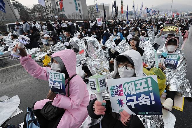 지난 5일 서울 한남동에서 은박 담요로 몸을 감싼 시위대가 ‘윤석열 체포’를 요구하고 있다. 연합뉴스